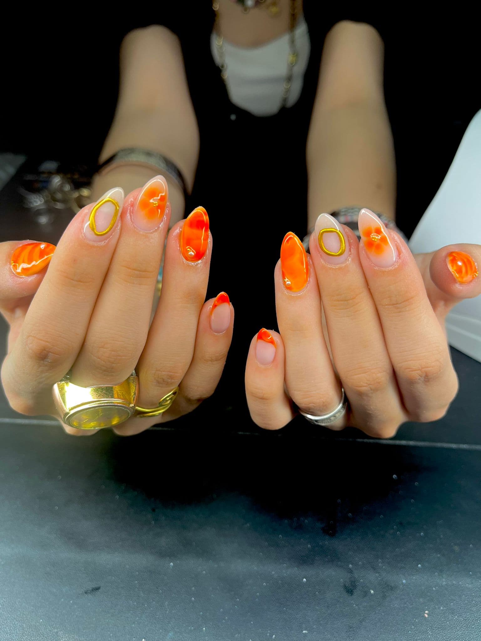 Nail art orange floral avec détails dorés