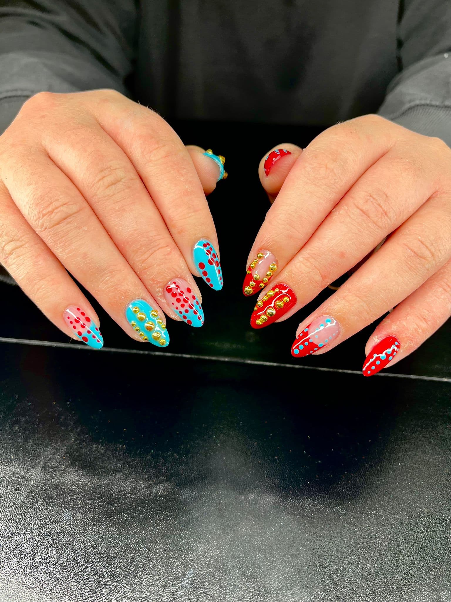 Nail art rouge bleu avec détails dorés